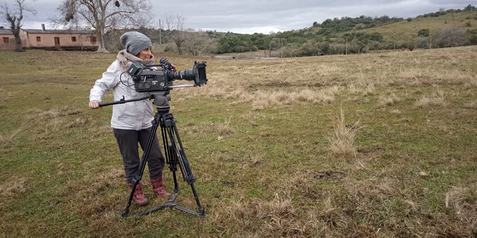 Marcia Paraiso em campo, com uma câmera na mão